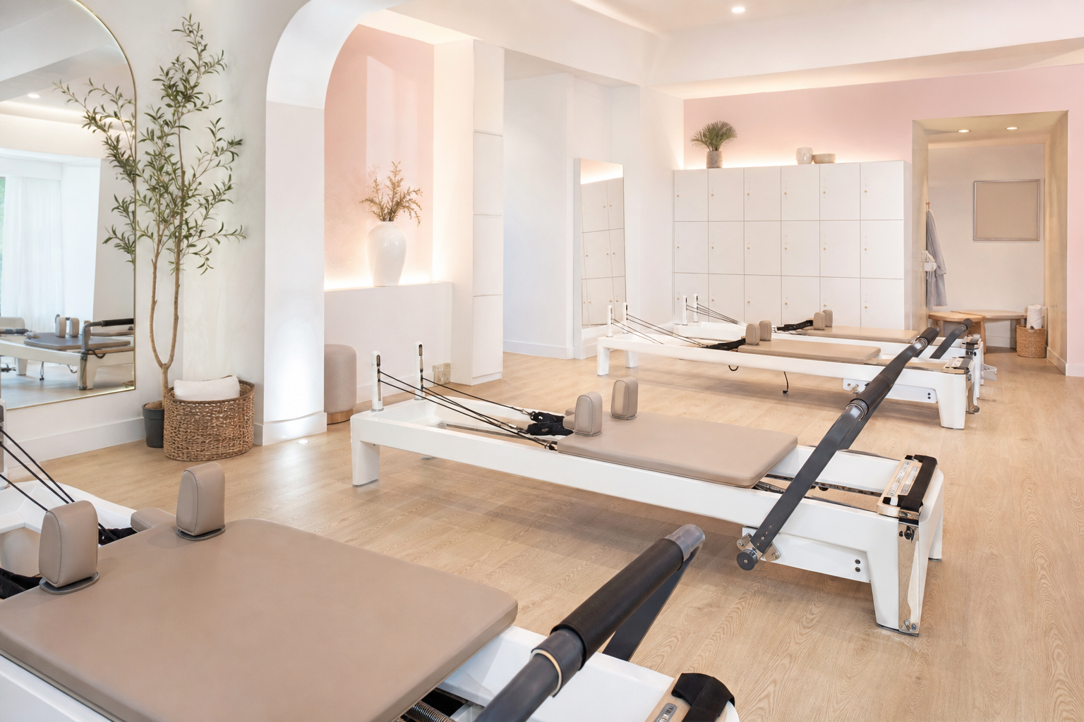 A modern, stylish women-only Pilates studio interior with a clean white and pastel color palette. Th